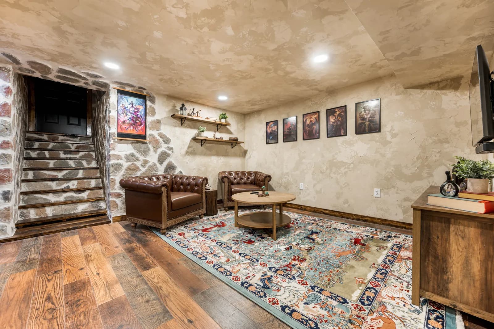 The lounge at the Dungeon: leather chairs and framed art under a stone stairwell
