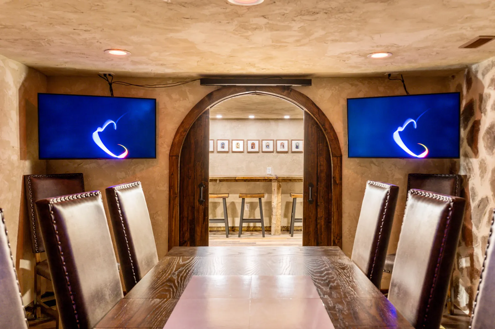 The head of the gaming table, flanked by screens set into the stone